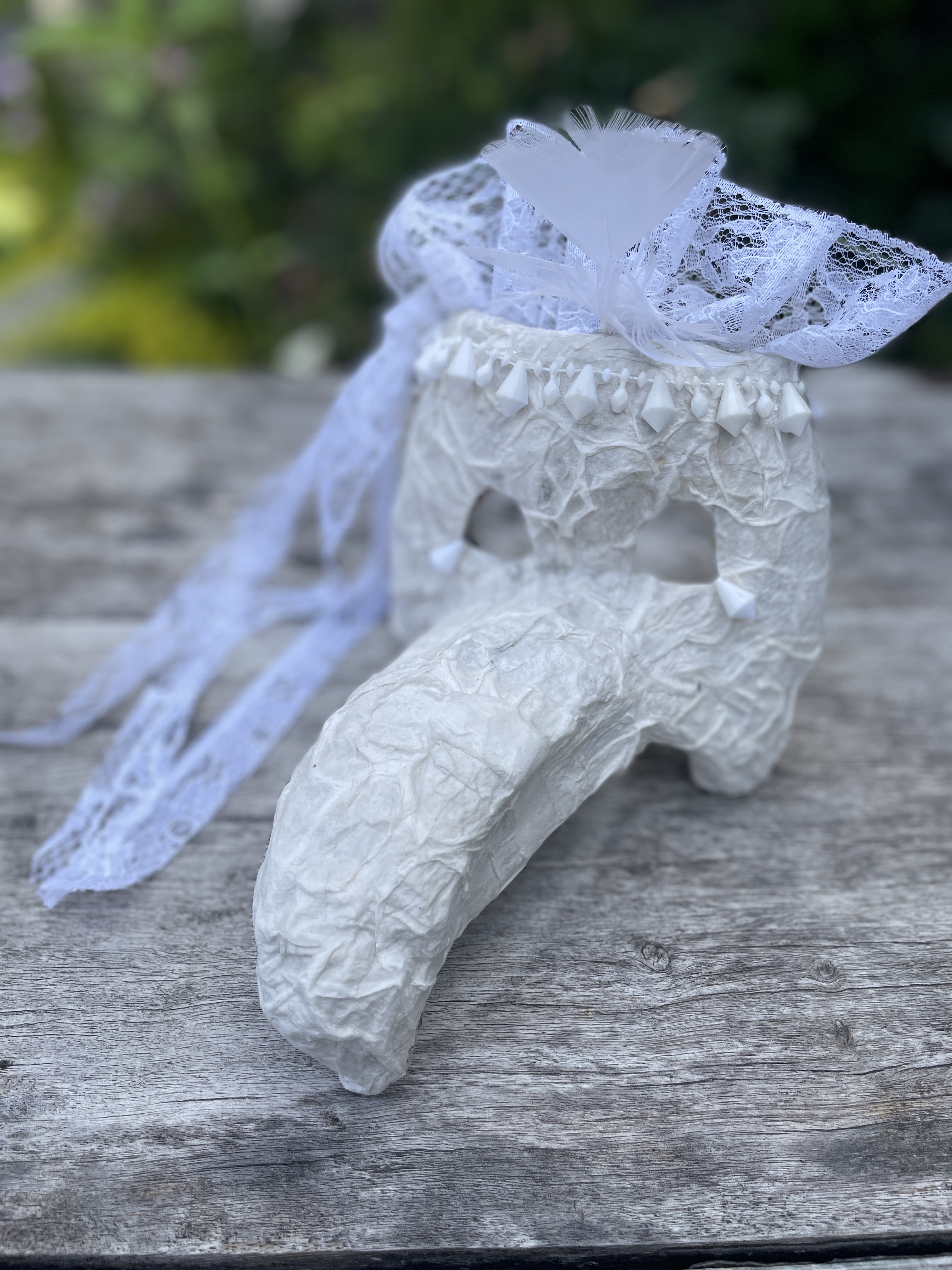 Nahaufnahme einer bemalten Maske mit Details und Materialien.